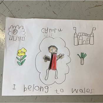posteri wedi'u hysgrifennu â llaw gyda 'Cymru' a 'rwy'n perthyn i Gymru' wedi'u hysgrifennu