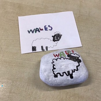 Painted rock and card with “Wales” and sheep drawing