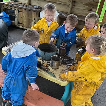 Group of children playing with mud in the school yard