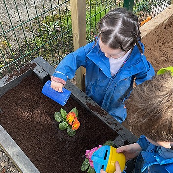 Two children playing together in the garden